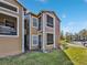 Tan two-story building with screened balconies and a grassy yard at 4350 Perkinshire Ln # 111, Orlando, FL 32822
