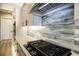Gas cooktop with stylish backsplash and modern range hood at 17694 Sw 61St Lane Rd, Dunnellon, FL 34432
