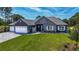 Single-Gathering home with stone and gray siding, three car garage at 17694 Sw 61St Lane Rd, Dunnellon, FL 34432