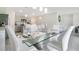 Elegant dining room with a glass table and white leather chairs at 1157 Torrente Ln, Haines City, FL 33844