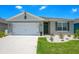 One-story home with white garage door and green accents at 1157 Torrente Ln, Haines City, FL 33844