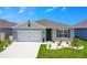 Charming one-story home with gray exterior, white garage door, and landscaping at 1157 Torrente Ln, Haines City, FL 33844