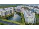 Aerial view of community with pond, lush landscaping, and buildings at 5300 S Atlantic Ave # 15-403, New Smyrna Beach, FL 32169