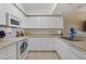 Modern kitchen with white cabinets, stainless steel appliances, and granite countertops at 5300 S Atlantic Ave # 15-403, New Smyrna Beach, FL 32169