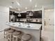 Kitchen island with seating, granite countertops, and dark brown cabinets at 3982 Lana Ave, Davenport, FL 33897