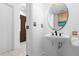 Simple bathroom with pedestal sink and round mirror at 2715 Autumn Green Dr, Orlando, FL 32822