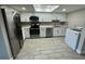 Updated kitchen with white shaker cabinets, stainless steel appliances, and gray tile floors at 6003 Village Cir # Ge, Orlando, FL 32822