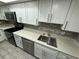 Modern kitchen featuring white cabinets, quartz countertops, and stainless steel appliances at 6003 Village Cir # Ge, Orlando, FL 32822