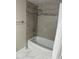 Updated bathroom featuring a bathtub and gray tile shower surround at 6003 Village Cir # Ge, Orlando, FL 32822