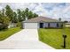 One-story home with gray siding, a two-car garage, and a well-manicured lawn at 15031 Sw 28Th Terrace Rd, Ocala, FL 34473