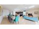 Open concept dining area with a long table and teal chairs at 1586 Lima Ave, Kissimmee, FL 34747
