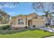 Tan two-story house with a two-car garage and well-manicured lawn at 2524 Dover Glen Cir, Orlando, FL 32828