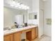 Double vanity bathroom with light wood cabinets and large mirror at 2524 Dover Glen Cir, Orlando, FL 32828