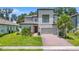 Two-story house with a gray exterior, brick driveway, and landscaping at 3860 Rose Malllow Dr, Kissimmee, FL 34746