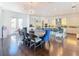 Modern dining room with a large wooden table and blue velvet chairs at 15680 Panther Lake Dr, Winter Garden, FL 34787