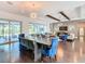 Elegant dining area with a farmhouse table and blue chairs, overlooking the living room and kitchen at 15680 Panther Lake Dr, Winter Garden, FL 34787