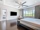 Main bedroom with hardwood floors and a large TV at 15680 Panther Lake Dr, Winter Garden, FL 34787