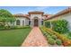 Home exterior with brick walkway, lush landscaping, and double doors at 3036 Seigneury Dr, Windermere, FL 34786