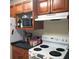 Kitchen with wood cabinets, microwave, and electric range at 6682 Time Square Ave # 101, Orlando, FL 32835
