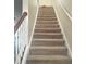 Carpeted staircase with wooden handrail at 6682 Time Square Ave # 101, Orlando, FL 32835
