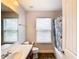 Bathroom with tub shower, vanity, and window with blinds at 1508 Caterpillar St, St Cloud, FL 34771