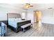 Main bedroom with a large bed, bench, and ceiling fan at 1508 Caterpillar St, St Cloud, FL 34771