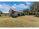 Large metal barn with a roll-up door, situated in a grassy field at 2017 W State Road 426, Oviedo, FL 32765