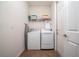 Convenient laundry room with washer, dryer, and shelving at 2588 Shanti Dr, Kissimmee, FL 34746