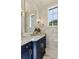 Stylish powder room with dark blue vanity and marble hexagon tile at 9832 Laurel Valley Dr, Windermere, FL 34786