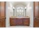 Vanity with granite countertop and wood cabinets in an elegant bathroom at 16716 Artimino Loop, Montverde, FL 34756