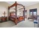 Main bedroom with four-poster bed, sitting area, and access to balcony at 16716 Artimino Loop, Montverde, FL 34756