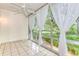 Bright sunroom with tiled floor and sheer curtains, offering a view of lush greenery at 700 Melrose Ave # E4, Winter Park, FL 32789