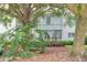 Landscaped backyard with lush tropical plants and large oak trees surrounding the building at 700 Melrose Ave # E4, Winter Park, FL 32789