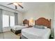 Guest bedroom with two twin beds and ceiling fan at 8125 Resort Village Dr # 5405, Orlando, FL 32821