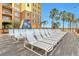 White lounge chairs on a sun deck next to a building at 8125 Resort Village Dr # 5405, Orlando, FL 32821