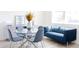 Charming dining area with glass table, blue velvet sofa, and four blue chairs at 7904 Waterfield Ave # 1, Orlando, FL 32832