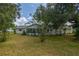 Home's backyard features a large grassy area and screened porch at 17775 Se 101St Ct, Summerfield, FL 34491