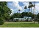 House with a blue roof and white walls, palm trees, and a grassy yard at 24650 Fox Rd, Astor, FL 32102