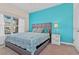 Bedroom with a king-size bed, turquoise accent wall, and modern dresser at 8984 Stinger Dr, Champions Gate, FL 33896