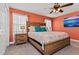 Primary bedroom with wood bed frame and coral walls at 8984 Stinger Dr, Champions Gate, FL 33896