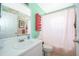 Bathroom with flamingo wallpaper, white vanity, and pink shower curtain at 132 Robbins Rest Cir, Davenport, FL 33896