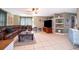 Living room with brown leather sectional sofa, large TV, and tile floor at 132 Robbins Rest Cir, Davenport, FL 33896