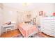 Charming bedroom with white dresser, metal bed frame, and hardwood floors at 132 Robbins Rest Cir, Davenport, FL 33896