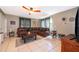Living room with brown leather sectional sofa, large TV, and tile floor at 132 Robbins Rest Cir, Davenport, FL 33896