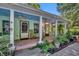 Inviting front porch with rocking chairs, brick flooring, and lush landscaping at 191 E Ponkan Rd, Apopka, FL 32712