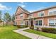 Two-story townhome with peach siding, white picket fence and a lush lawn at 2211 San Vittorino Cir # 105, Kissimmee, FL 34741