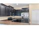 Modern kitchen with dark cabinetry, granite counters and stainless steel appliances at 8940 Azalea Sands Ln # 8940, Davenport, FL 33896
