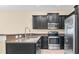 Modern kitchen with dark cabinetry, granite counters and stainless steel appliances at 8940 Azalea Sands Ln # 8940, Davenport, FL 33896