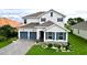 Two-story house with gray roof and blue garage doors at 30053 Island Club Dr, Tavares, FL 32778