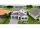 Two-story house with gray roof and blue garage doors at 30053 Island Club Dr, Tavares, FL 32778